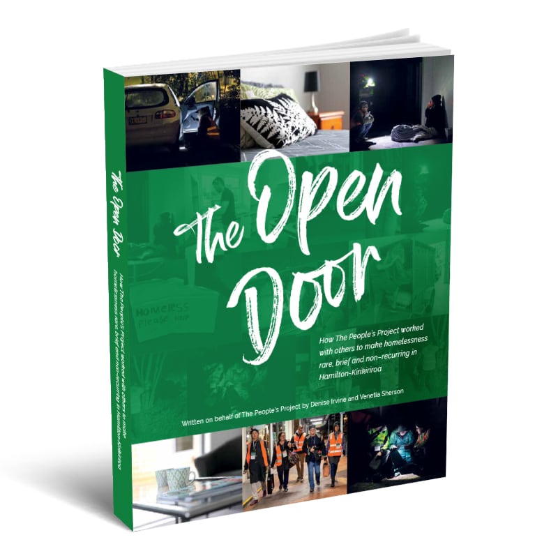 The Open Door book positioned at an angle, with the front cover visible. It has a photo montage top and bottom, with solid green colour in the middle and white scripted writing: The Open Door